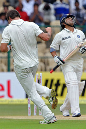 A disgruntle  Sachin Tendulkar goes past Doug Bracewell as he celebrates his wicket © Getty Images