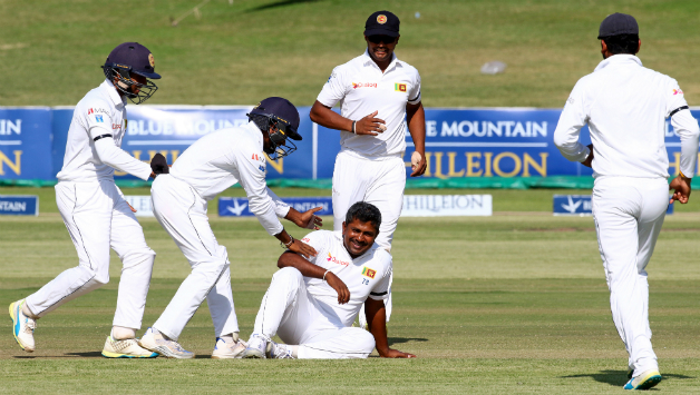 Sri Lanka players mob around skipper Rangana Herath who fell down during an appeal © AFP