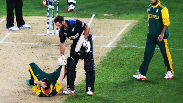 Grant Elliott helps Dale Steyn up after winning the 2015 Cricket World Cup semi-final match between New Zealand and South Africa at Eden Park © Getty Images