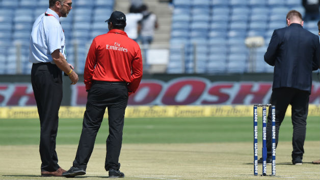 ICC match refree Chris Broad (L) inspecting the pitch at Pune © AFP